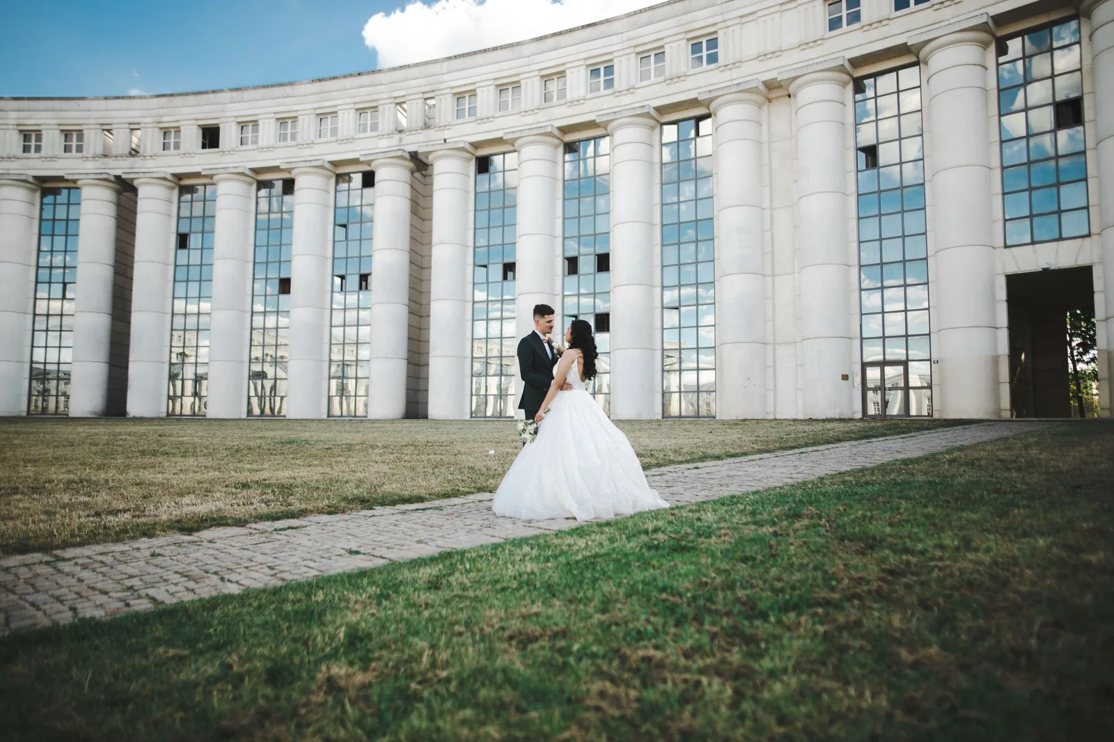 Couple de mariés devant un bâtiment néoclassique à colonnades